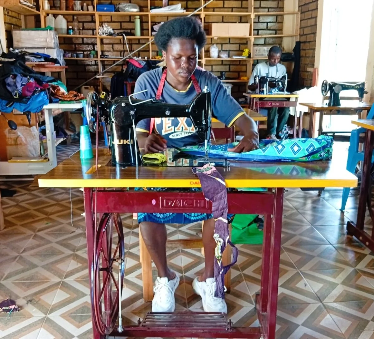  A beneficiary operates a sewing machine during a community skills development initiative aimed at promoting youth employment and economic empowerment.